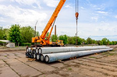 unloading of concrete high voltage poles at the construction site using a lifting crane